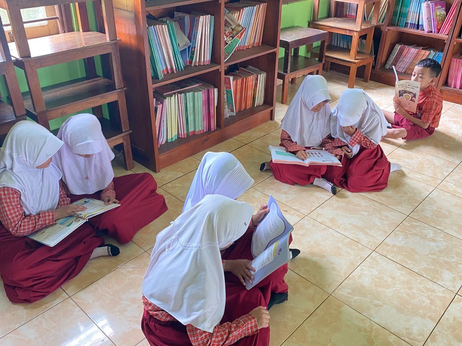 membaca buku di perputakaan